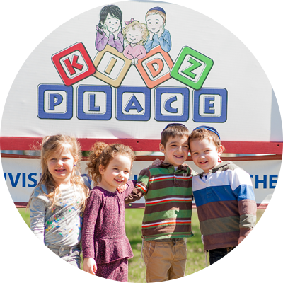 Children Smiling Near the Kidz Place Logo-Billboard at the Site's Entrance